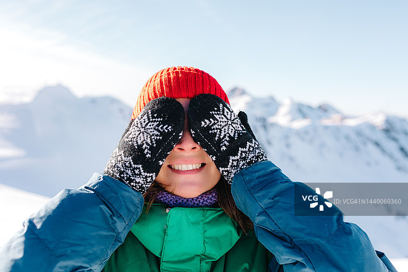 冬天的山里，女人戴着手套用手捂着眼睛玩图片素材