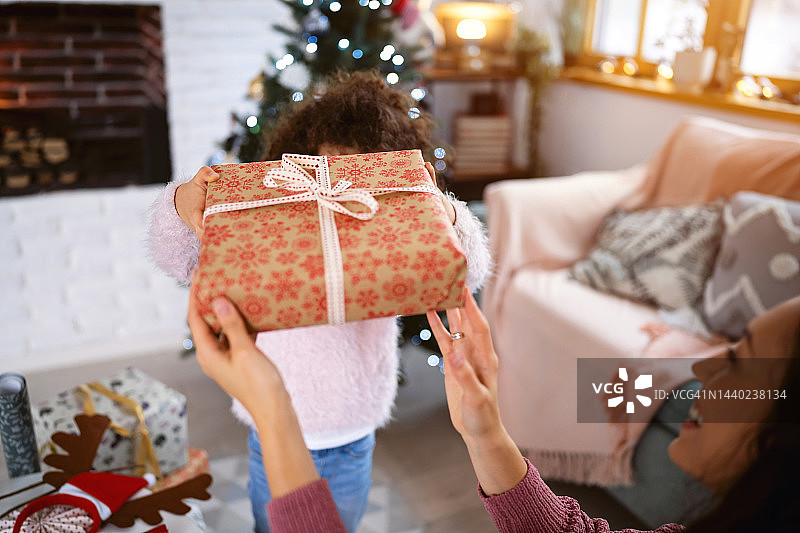 女儿帮助她的母亲包装和装饰圣诞礼物图片素材