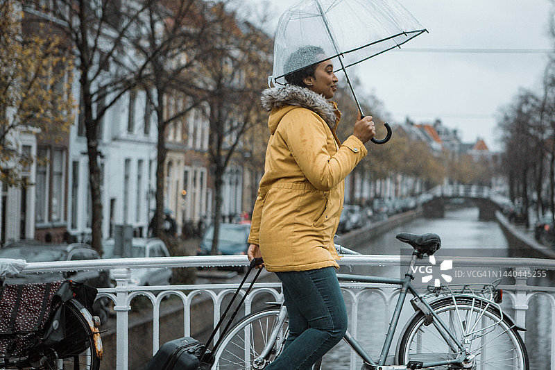 一个雨天，在代尔夫特通勤的黑人女商务女旅行者图片素材