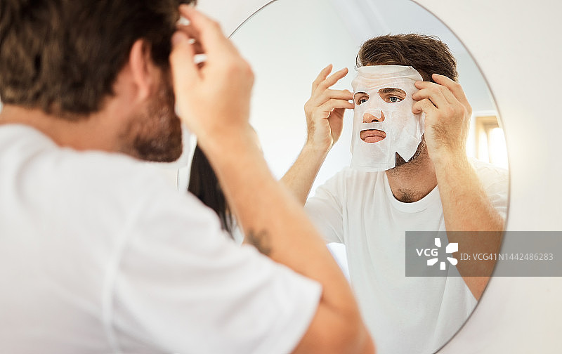 在家庭浴室的镜子上，在男人身上涂护肤、面部和面膜。年轻男性以自我护理、美容或美容清洁为护肤保健，以抗衰老保湿产品为养生排毒图片素材