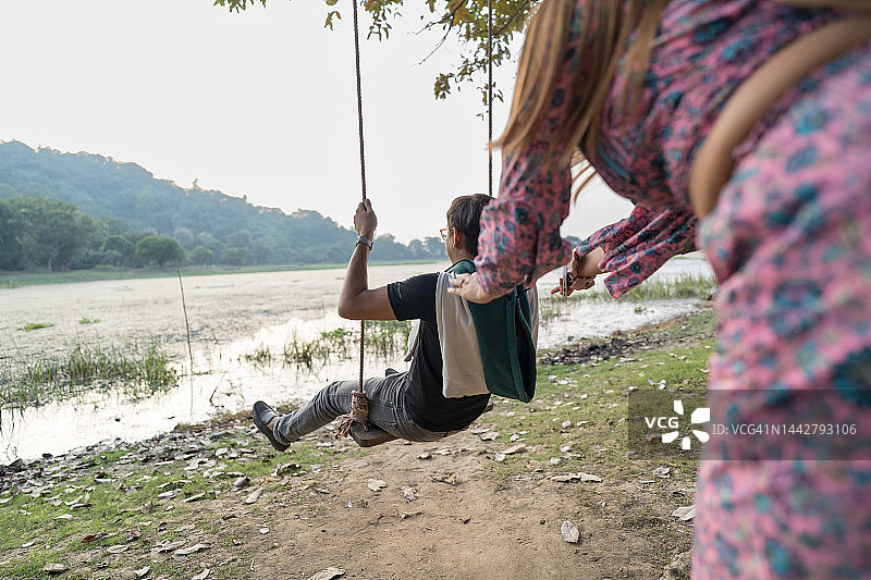 年轻夫妇在湖边玩得很开心。图片素材