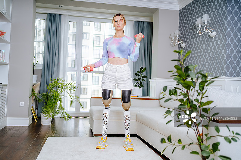 残疾女性举重。戴着假肢的金发女人在家做有氧运动图片素材