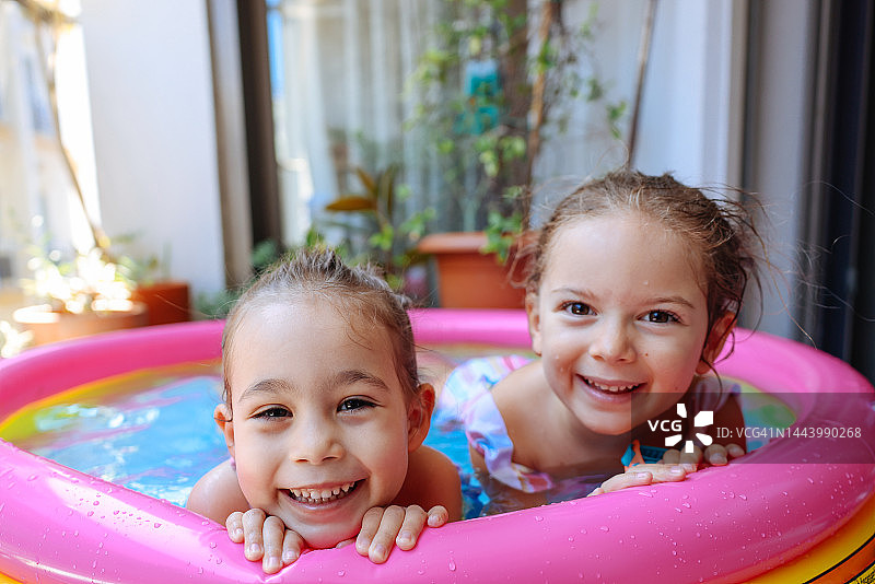 快乐的小女孩们在泳池里玩耍图片素材