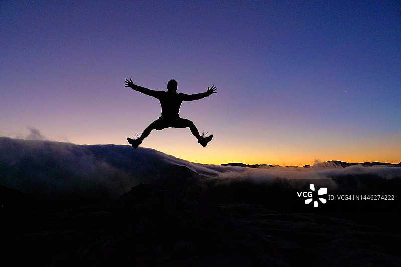 人的剪影跳跃在日出在山上|新西兰图片素材
