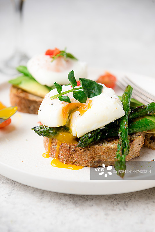 荷包蛋加吐司、牛油果、芦笋、西红柿和豆芽是健康的早餐图片素材