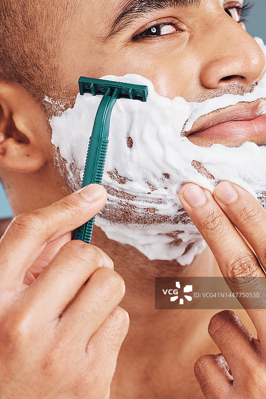 剃须刀，泡沫和男人剃须的卫生，健康和光滑的皮肤在一个工作室。剃须刀，来自印度的干净英俊的家伙，为皮肤健康或面部治疗梳理面部毛发。图片素材