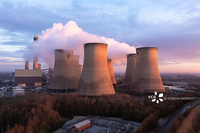 日落时燃煤发电厂冷却塔污染排放的鸟瞰图图片素材