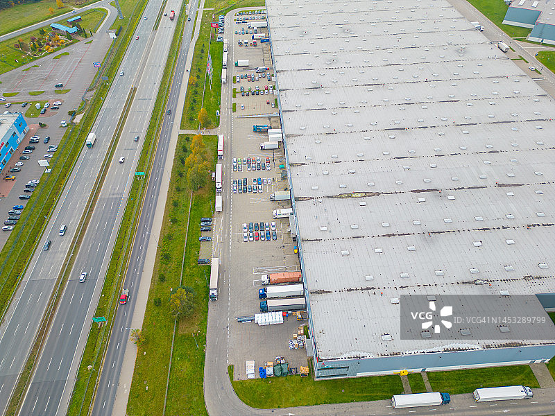 货物仓库鸟瞰图。物流中心在工业城区以上。物流中心装货卡车鸟瞰图图片素材