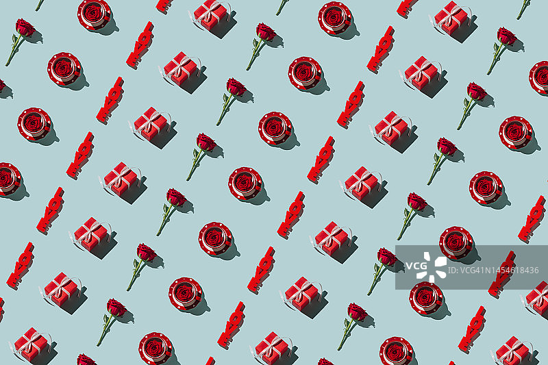 情人节背景:2月14日。图案马克杯与心和红玫瑰花，字爱，礼盒上的蓝色背景。浪漫的情人节概念。平铺，俯视图。图片素材