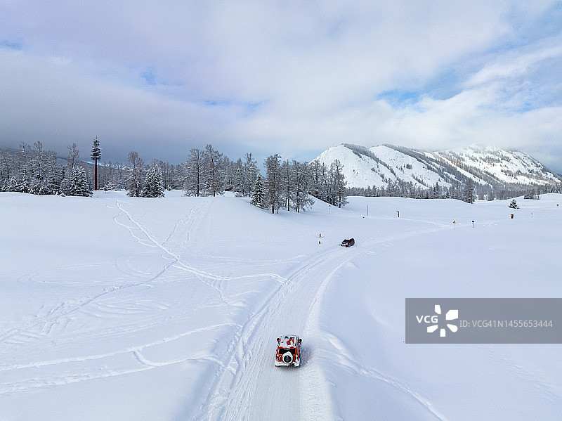 汽车在广阔的雪地上行驶图片素材