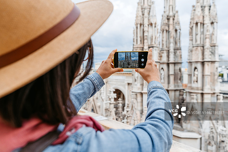年轻的女游客在米兰大教堂拍摄风景图片素材