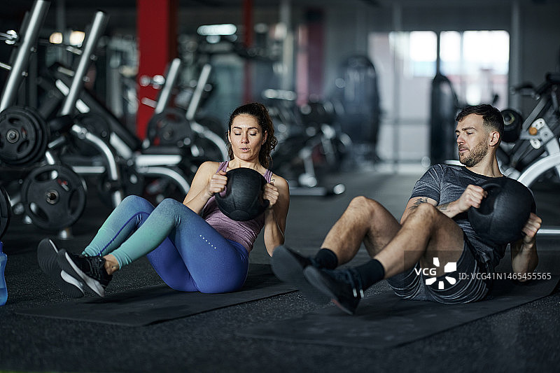 年轻的运动员夫妇在健身房锻炼力量。图片素材