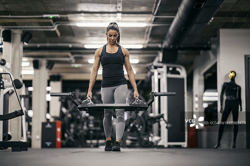 一位强壮的女运动员正在健身房进行力量训练。图片素材