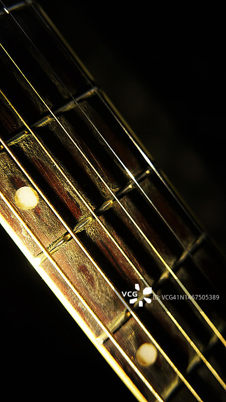 乐器:旧吉他弦。吉他脖子。吉他手臂特写镜头。钢弦图片素材