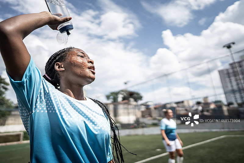 女足球运动员在球场上洗脸图片素材