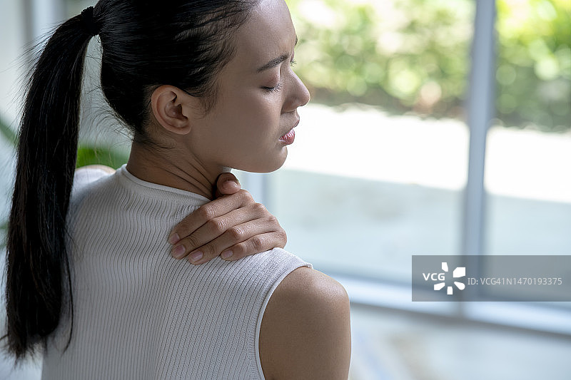 亚洲女性有颈部和肩部疼痛。图片素材