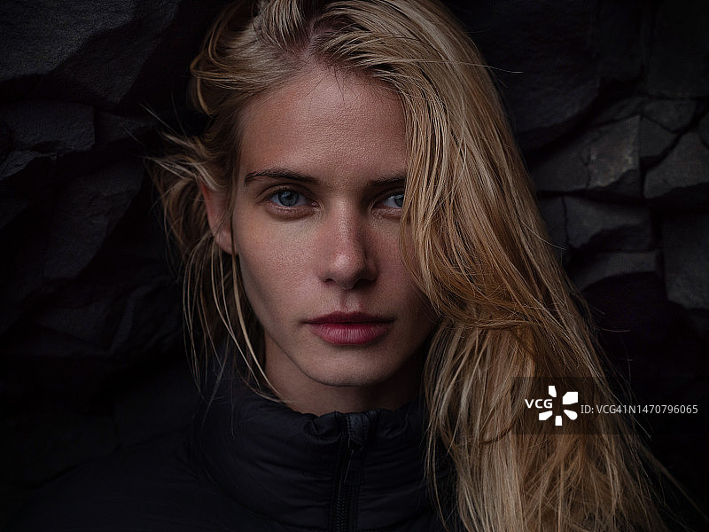 一个美丽的金发女孩在冰岛黑山的背景下的肖像图片素材