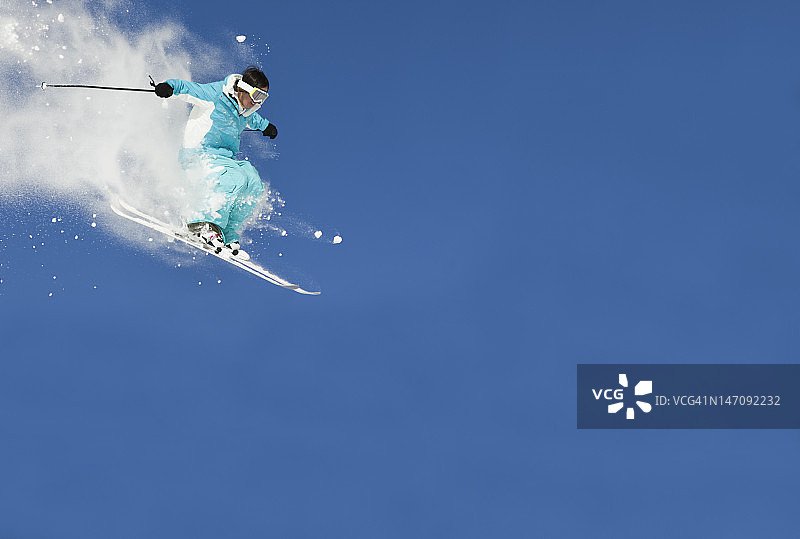 滑雪跳跃的近景对抗清澈的蓝天图片素材