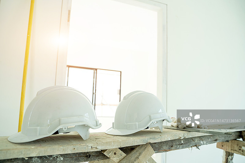 建筑工人的安全帽放在建筑工地的桌子上。图片素材