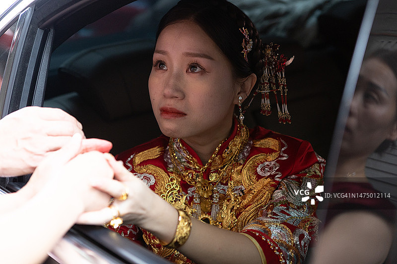 一位美丽的中国新娘在车里向她的母亲告别图片素材