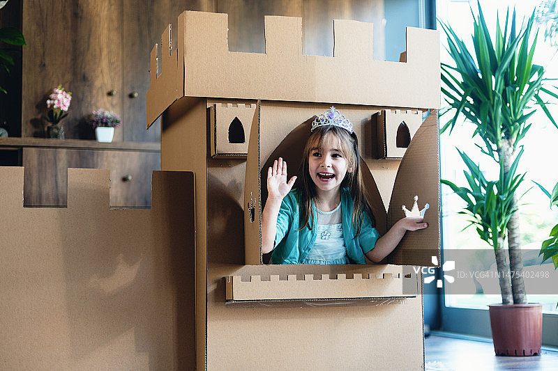 可爱的小公主在家里玩角色扮演游戏，用纸板做的城堡图片素材