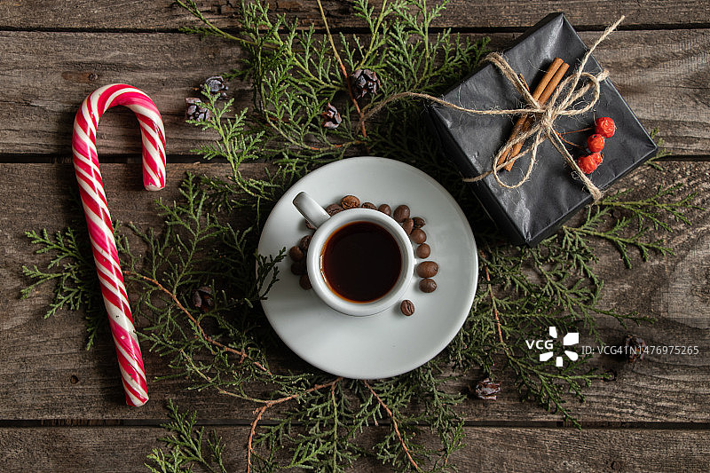 一杯咖啡豆旁边的焦糖和一个盒子的背景上有一棵绿色的圣诞树的木桌，新年的装饰图片素材