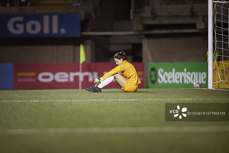 输球后，守门员失望地坐在足球场上图片素材