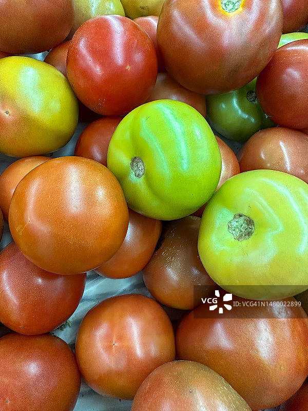 全帧图像的新鲜农产品市场的成熟的红色和未成熟的绿色西红柿(茄)堆，高架视图图片素材