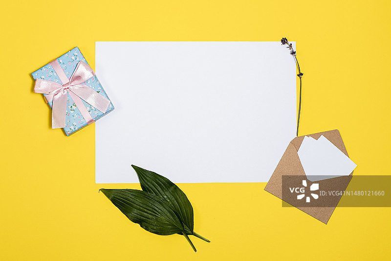 白色床单，信封，礼品盒躺在一个黄色背景，罗马尼亚图片素材