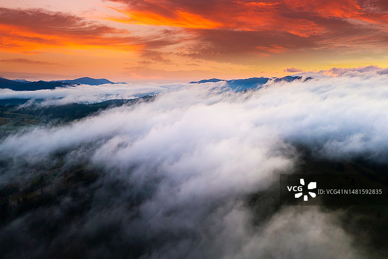 山上雾蒙蒙的黎明鸟瞰图。图片素材