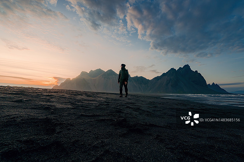 背包客在日落时漫步在冰岛的斯托克森海滩上，在著名的地方拍摄风景，奇妙的欲望图片素材