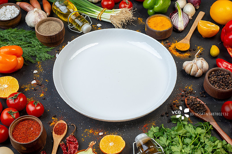下图白色圆盘黑胡椒在小碗油瓶香菜大蒜莳萝葱在桌子上，罗马尼亚图片素材