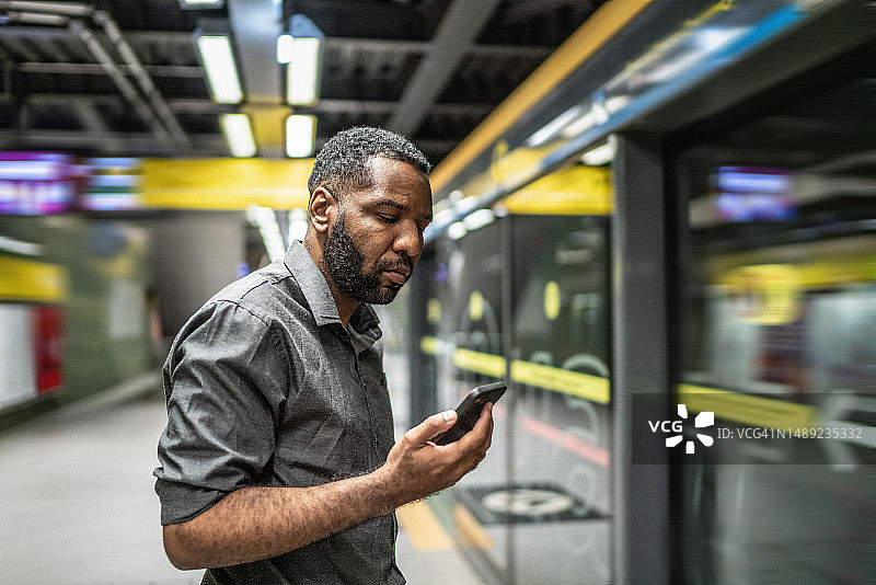 中年男子在地铁站使用手机图片素材