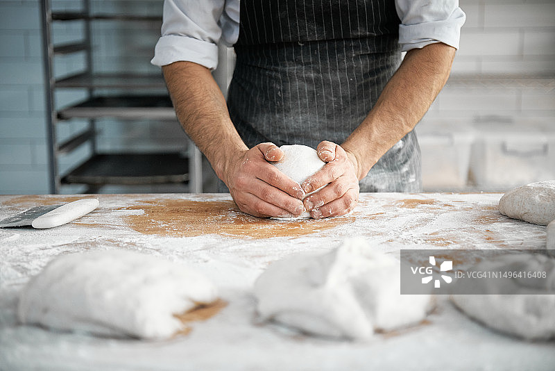 厨师在厨房柜台上揉面制作手工面包的手图片素材