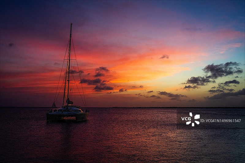 日落时海上帆船的剪影映衬着天空图片素材