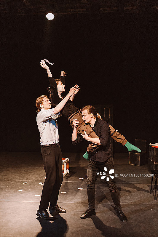 三个充满激情的学生戏剧俱乐部的年轻成员在舞台上表演图片素材
