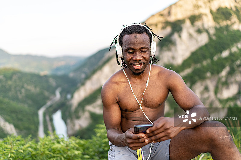 积极健康快乐的非裔美国跑步者，戴着耳机听音乐图片素材