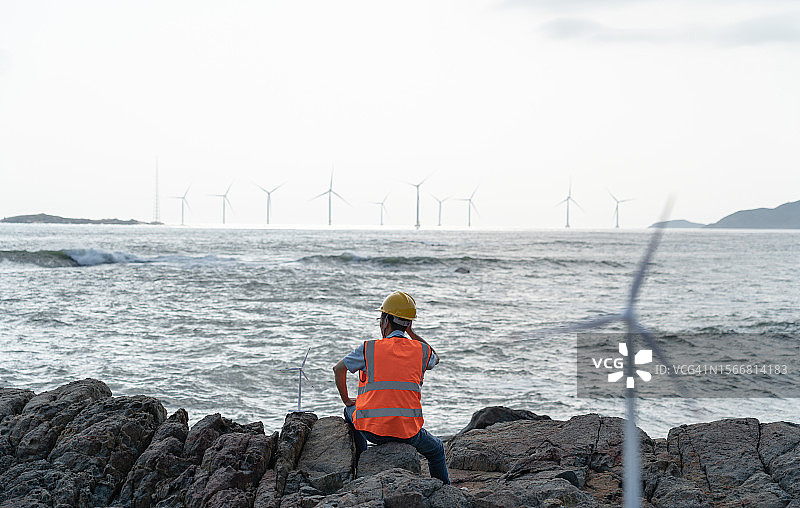 海上风力发电场一名男性技术人员的背部图片素材