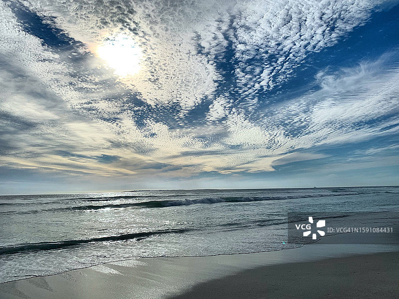 2022年10月，南非布鲁伯格斯特兰德海滩的桌湾大西洋上壮观的天空。冬日的阳光洒在宁静的海面上，海浪拍打着空旷的沙滩。日落时美丽干净的海滩图片素材