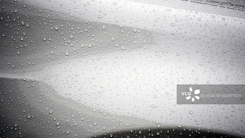法国巴黎，一辆被雨滴覆盖的白色汽车的前挡泥板图片素材