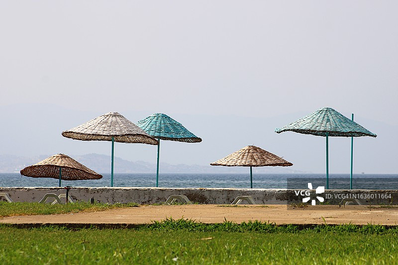 沙滩上的柳条沙滩伞。
沙滩和沙滩上的雨伞。图片素材