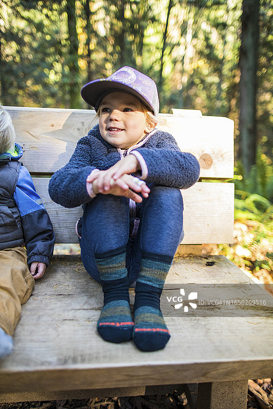 小女孩穿着舒适的袜子坐在长凳上图片素材