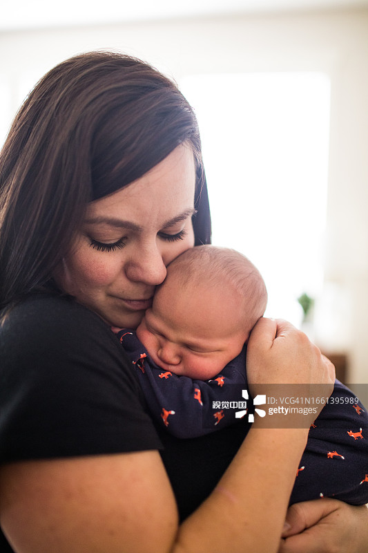 年轻迷人的母亲抱着她刚出生的婴儿图片素材