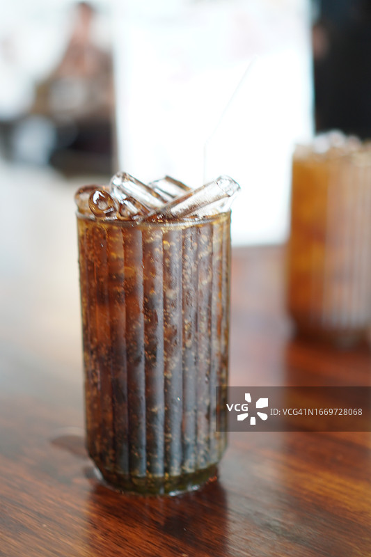 饮料、冰镇可乐装在塑料杯里，放在木桌上图片素材