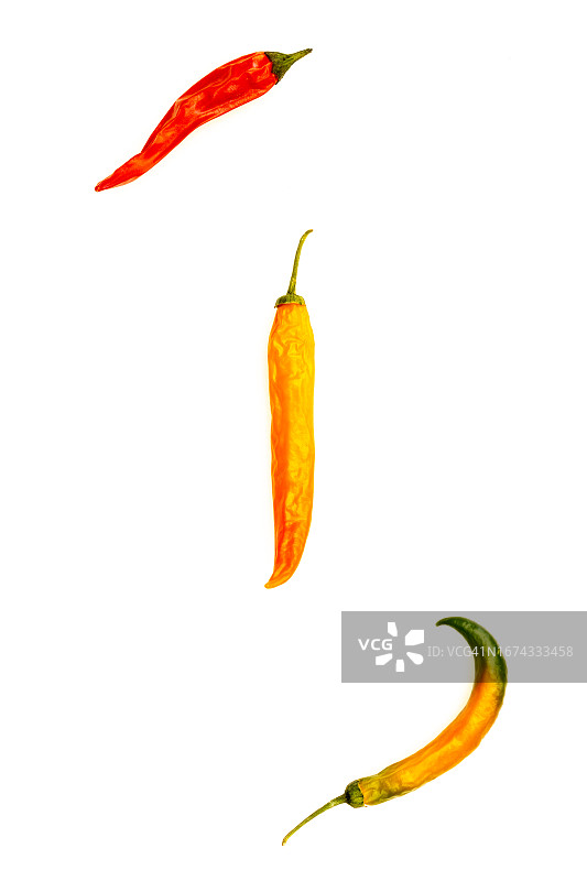 三个橙色、红色和绿色辣椒在白色背景上晒干的库存照片图片素材