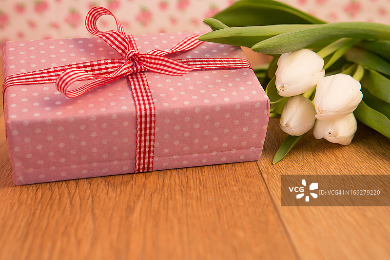 粉红色包装的礼物和一束白色郁金香图片素材