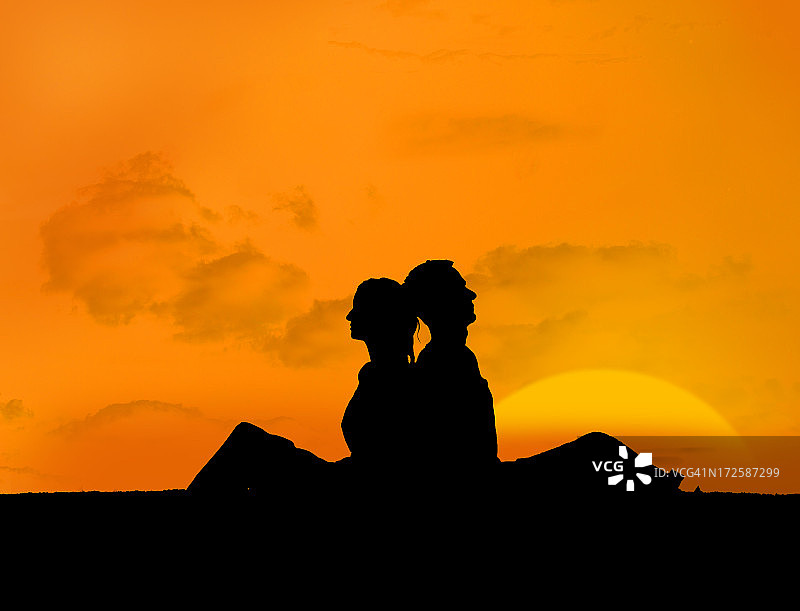一对情侣在夕阳下放松的剪影图片素材