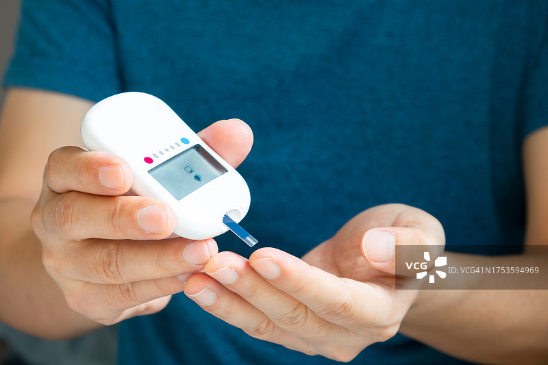 人们的手检查糖尿病和高血糖监测仪与数字压力表。医疗保健和医疗理念图片素材