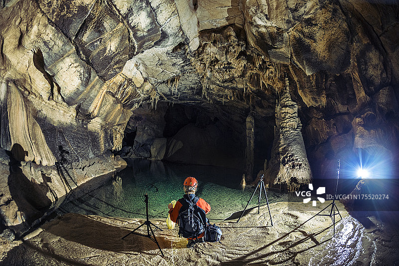 摄影师准备在洞穴深处拍摄图片素材