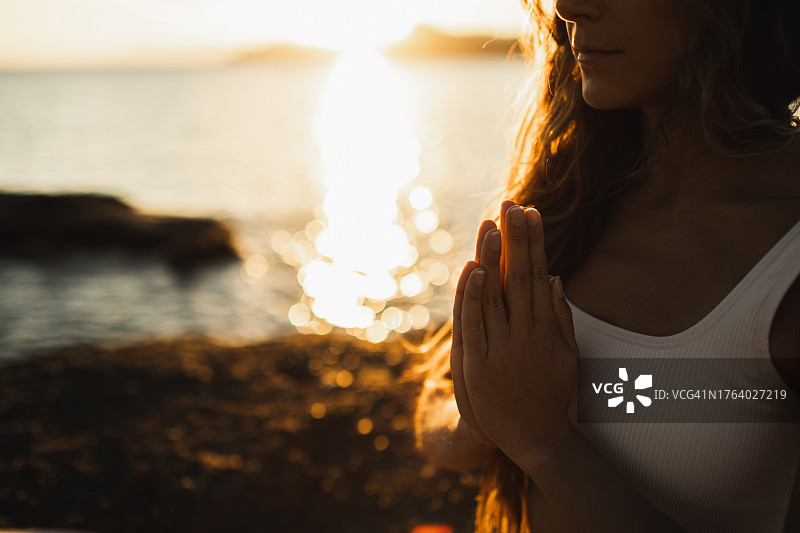 瑜伽和冥想的概念。合上女性的双手，保持祈祷的姿势。正念，平静和安静。图片素材